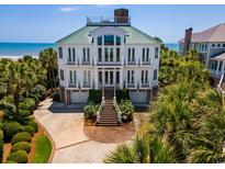 Stunning three-story beachfront home boasting an amazing top-level deck, manicured landscaping, and private beach access at 100 Ocean Park Loop, Georgetown, SC 29440