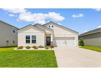 Charming home with manicured lawn, beautiful flowerbed and a driveway leading to a one car garage at 1029 Saltgrass Way, Myrtle Beach, SC 29588