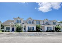 View of the townhomes with beige siding, blue shutters, and well-maintained landscaping at 105 Spring Creek Dr. # C, Myrtle Beach, SC 29588