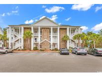 Spacious condominium with brick and white facade with palm trees and ample parking at 118 Birch N Coppice Dr. # 2, Surfside Beach, SC 29575