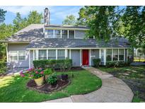 Charming two-story home featuring gray siding, a red front door, manicured landscaping, and a curved walkway at 1205 Erin Way # 5C, Myrtle Beach, SC 29577