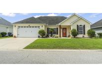 Charming single-story home featuring an attached two-car garage, well-manicured lawn, and inviting front porch at 131 River Country Dr., Conway, SC 29526