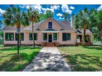 Charming pink two-story home with landscaped yard and mature palm trees at 1311 9Th Ave., Conway, SC 29526