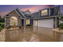 Beautiful blue home featuring a two-car garage, stone accents, and manicured landscaping at 1844 Wood Stork Dr., Conway, SC 29526