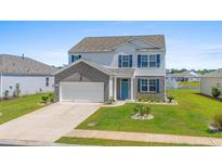 Charming two-story home with blue shutters and a well-manicured lawn and pond view at 2106 Ainsley Dr., Little River, SC 29566