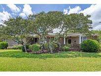 Charming brick home featuring mature trees and a well-manicured lawn at 3907 N Ocean Blvd., Myrtle Beach, SC 29572