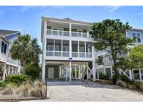 Inviting raised beach home featuring dual screened porches and charming coastal curb appeal at 421 30Th Ave. S, Sunset Beach, NC 28468