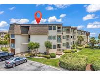 Exterior view of condo building with multiple balconies, landscaping, and ample parking space at 5601 N Ocean Blvd. # B316, Myrtle Beach, SC 29577