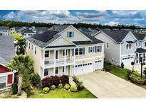 Stunning two-story home with solar panels, double garage, lush landscaping, and charming double porches at 6186 Chadderton Circle, Myrtle Beach, SC 29579