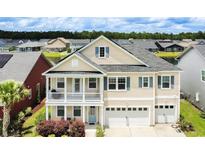 Charming home with a two-car garage, light siding, blue shutters, and a second-story balcony at 6186 Chadderton Circle, Myrtle Beach, SC 29579