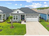 Charming home featuring well-manicured lawn, a two-car garage and inviting front entrance with beautiful landscaping at 6304 Chadderton Circle, Myrtle Beach, SC 29579