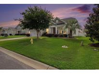 Charming single-story home featuring lush green lawn, mature trees, and vinyl siding at 632 Lafayette Park Dr., Little River, SC 29566