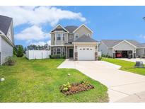 Charming two-story home featuring stone accents, a two-car garage, and a well-manicured front lawn at 724 Hobonny Loop, Longs, SC 29568