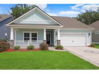 Charming single-story home featuring a quaint front porch, well-manicured lawn, and attached two car garage at 865 Summer Starling Pl., Myrtle Beach, SC 29577