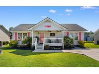 Charming single-story home with a covered porch, bright pink accents, and a well-manicured lawn at 9466 Old Palmetto Dr., Murrells Inlet, SC 29576