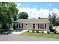 Charming one-story home featuring a red door, shutters, and nicely landscaped front yard at 950 Tiffany Ln., North Myrtle Beach, SC 29582
