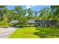 Charming brick ranch with a covered carport, lush lawn, and mature landscaping at 1032 Chelsey Circle, Conway, SC 29526