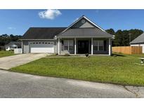 Charming single-story home with a well-manicured lawn and a two-car garage at 140 Blue Pride Dr., Loris, SC 29569
