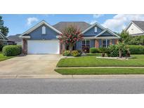 Charming home featuring a well manicured lawn, flowering tree, brick accents, and an attached garage at 2369 Clandon Dr., Myrtle Beach, SC 29579