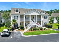 Inviting two-story condo building with white siding, well-maintained landscaping, and a prominent staircase entrance at 314 Black Oak Ln. # 102, Murrells Inlet, SC 29576