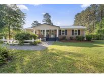 Charming brick home featuring a well-maintained lawn and a classic white picket fence at 3269 Sims Rd., Marion, SC 29571