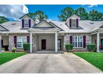 Charming townhome with brick accents, metal roof, and manicured landscaping at 456 Colonial Trace Dr. # 13-E, Longs, SC 29568