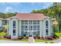 Attractive condo building with multiple balconies and manicured landscaping offering a relaxing outdoor space at 4650 Greenbriar Dr. # A5, Little River, SC 29566