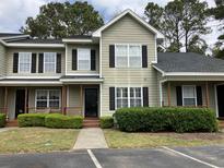 Charming two-story home featuring a covered front porch and well-maintained landscaping at 4840 Moss Creek Loop # 31, Murrells Inlet, SC 29576