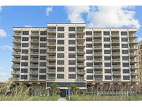 Beautiful multi-story beachfront condo building with private balconies and manicured landscaping at 523 S Ocean Blvd. # 305, North Myrtle Beach, SC 29582