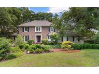 Charming brick home featuring mature landscaping, a manicured lawn, and a welcoming front entrance at 571 Fernwood Rd., Murrells Inlet, SC 29576