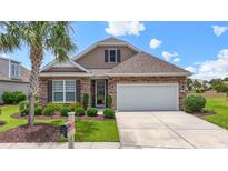 Charming single Gathering home featuring a well-manicured lawn, stone accents, and an attached two car garage at 5716 Lombardia Circle, Myrtle Beach, SC 29579