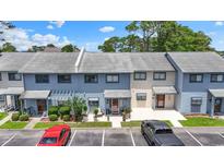 Charming townhome featuring a light-blue facade, a cozy patio, and well-manicured landscaping at 775 Plantation Dr. # 53, Little River, SC 29566