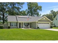 Well-maintained home with green lawn, solar panels, and American flag at 1100 Rosetta Dr., Conway, SC 29526