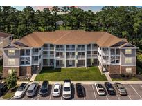 Three-story condo building featuring white railings, a well-manicured lawn, and convenient parking at 125 South Shore Dr. # 204, Longs, SC 29568