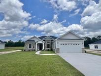 Inviting single-story home featuring stone accents, a two-car garage, and a well-manicured lawn at 189 Norris Ln, Loris, SC 29569