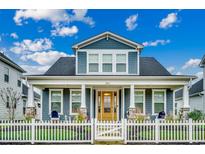 Charming two-story home with a welcoming front porch, white picket fence and a beautifully landscaped yard at 2023 Singing Palm Loop, Little River, SC 29566
