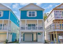 Charming raised beach home featuring a light blue exterior, white trim, and covered porch at 2308 Seaseeker Ln., Myrtle Beach, SC 29577