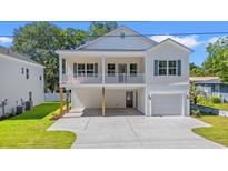 Charming two-story white home featuring a covered porch, attached garage, and well-maintained lawn at 2426 Park St., North Myrtle Beach, SC 29582