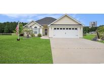 Charming home with a two-car garage, well-manicured lawn, and patriotic American flag at 280 Macarthur Dr., Conway, SC 29527