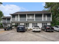 Two story condo building featuring white facade, upper level balconies, and ample parking in front at 403 71St Ave. N # 5, Myrtle Beach, SC 29572