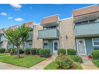 Charming townhouse with brick facade, blue trim, small balconies, and well-maintained landscaping at 4701 N Kings Hwy. # 8, Myrtle Beach, SC 29577
