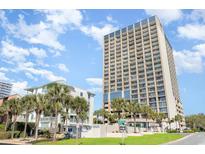View of the condo complex featuring lush landscaping and a high-rise building with ocean views at 5523 N Ocean Blvd. # 1410, Myrtle Beach, SC 29577