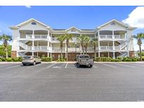 Beautiful condo building with multiple levels, palm trees, ample parking, and manicured landscaping at 5801 Oyster Catcher Dr. # 431, North Myrtle Beach, SC 29582