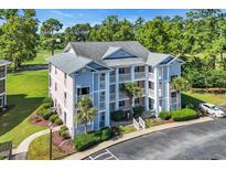 Attractive condo building featuring multiple balconies, lush landscaping, and ample parking at 605 Waterway Village Blvd. # 31A, Myrtle Beach, SC 29579