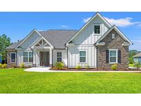 Charming home with white siding, stone accents, manicured lawn, and inviting front entrance at 609 Mccown Dr., Conway, SC 29526
