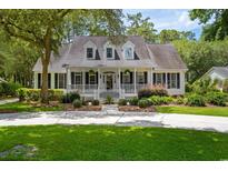 Charming home with a welcoming front porch, manicured landscaping, and a long driveway at 77 Capt Anthony White Ln., Georgetown, SC 29440