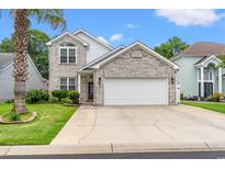 Charming two-story home with light brick, well-maintained landscaping, and a two-car garage at 867 Cardinal Pl., North Myrtle Beach, SC 29582