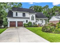 Charming two-story home with a well-manicured lawn, two-car garage, and inviting front porch at 1064 Links Rd., Surfside Beach, SC 29575
