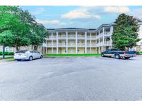 Exterior view of the three-story condo building featuring balconies and parking at 110 South Shore Blvd. # 203, Longs, SC 29568
