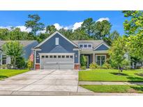 Charming blue home showcasing a well-manicured lawn, complemented by a concrete driveway and an attached two-car garage at 1314 Prescott Circle, Myrtle Beach, SC 29577